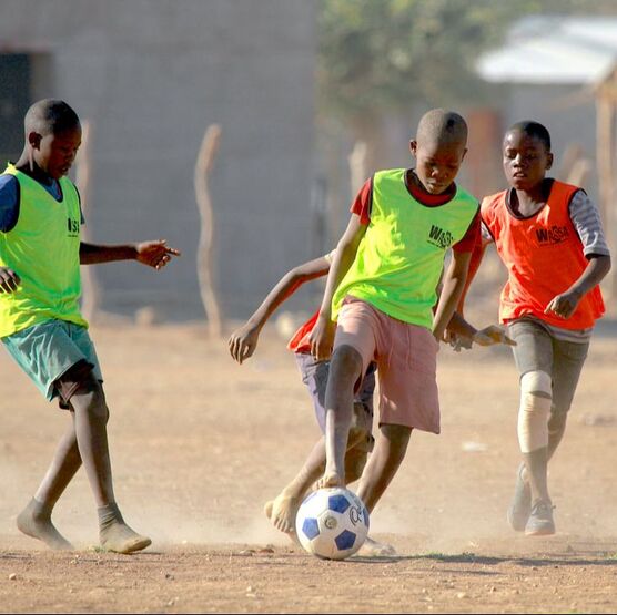 This image depicts youth football players, located in Warmquelle, Namibia. 