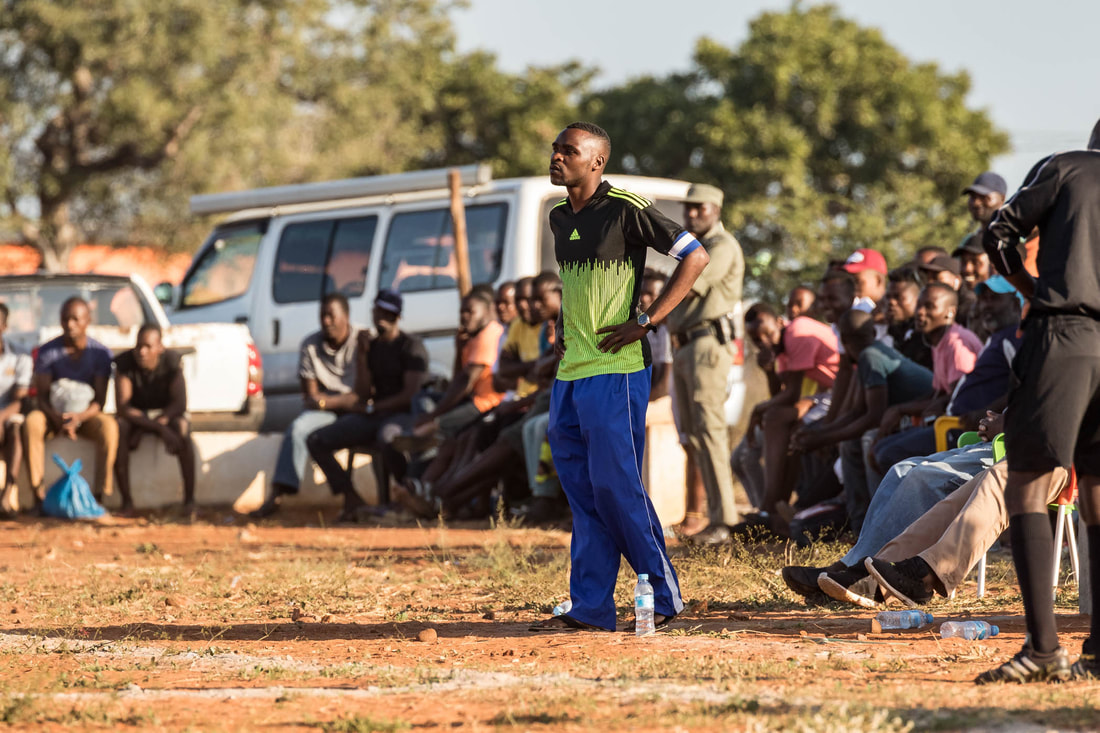 With a serious expression, Orlando Cossa, coach of Club de Corumana, places his hands on his hips and looks at his team, Corumana FC, during the early stages of the 2019 Rhino Cup Champions League season. The game took place at the Corumana soccer field in Mozambique.